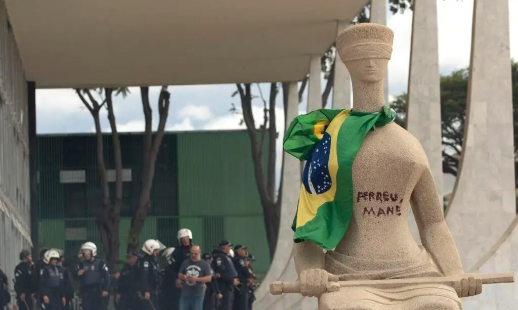 participar dos atos e pichar a frase "Perdeu, mané" na estátua A Justiça , local
